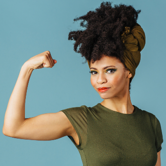 A stock image of woman flexing bicep looking at camera
