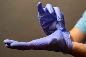 A stock image of person putting gloves on