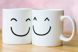 An image of coffee cups with smiling faces