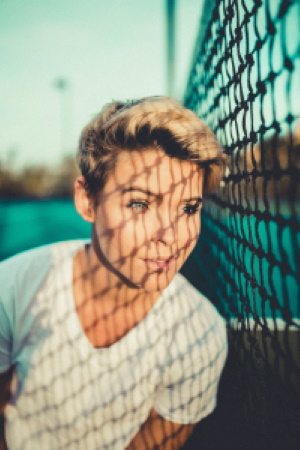 beautiful girl looking through a fence