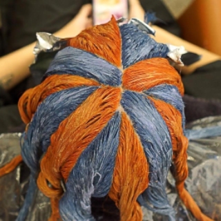 Blue and orange pinwheel hair color technique processing on a client