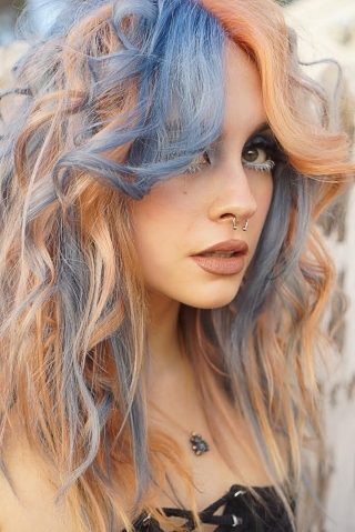 The finished result of a blue and orange pinwheel hair color technique. 