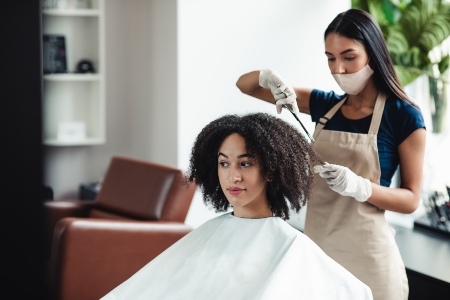 An image of hairstylist cutting hair