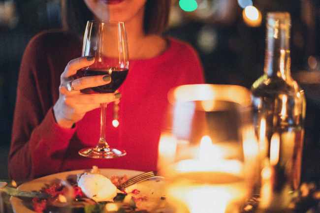 A stock image of woman with wine glass at meal