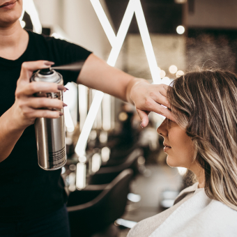 An AHP member spraying hair of client