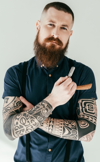 An image of AHP member barber with tattooed arms