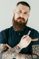 An image of AHP member barber with tattooed arms