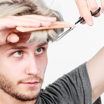 An image of male cutting his own bangs