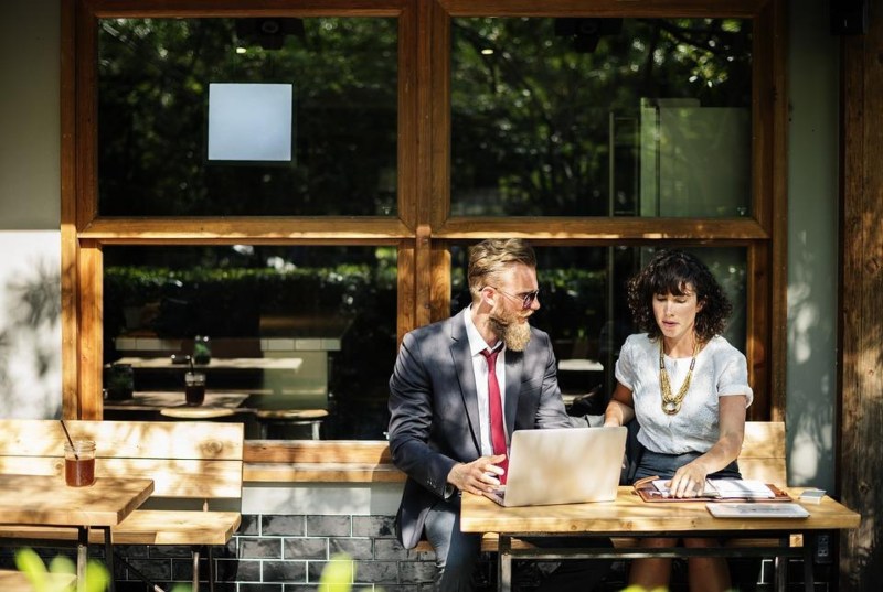 A stock image of man and woman using laptop sitting at table