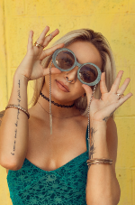 A stock image of woman wearing sunglasses on yellow background