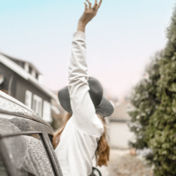 Associated Hair Professionals member waving from a car.