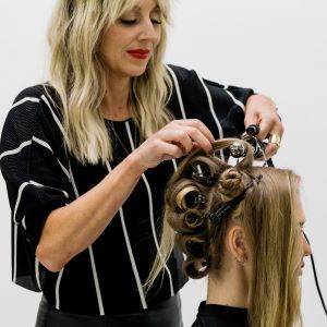 Hair stylist Anna Peters curls the back section of her client's hair in spirals for a faux shag look.