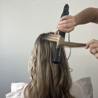 Bride getting her hair curled.