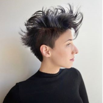 Side profile of an undercut pixie haircut styled with volume on top. 