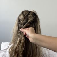 Adding twists in hair to create a boho bridal bun.