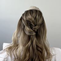 Adding twists in hair to create a boho bridal bun.