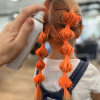 Woman using orange hair color on her hair.