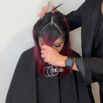 A hair client has her fringe bangs isolated in a triangle as one step in the octopus haircut process.