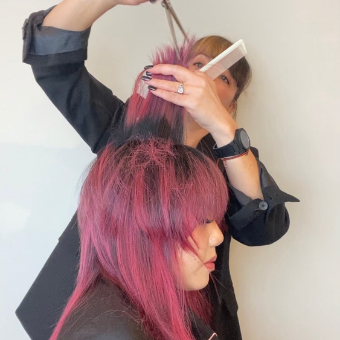 A hairstylist point cuts on her client to finish up an octopus haircut. 