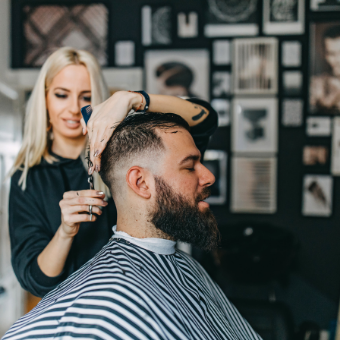 Hairdresser clipping client's hair