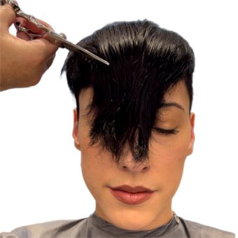 A hairstylist adds texture to their client’s pixie haircut with point cutting sheers.
