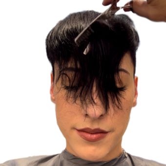 A hairstylist finishes up an undercut pixie with point cutting sheers.