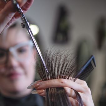 Cosmetologist cutting hair