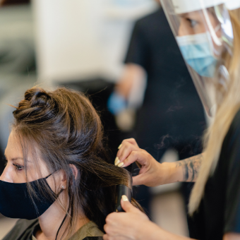 woman in a hair salon wearing a COVID mask