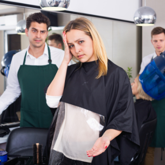 client holds head with stylist
