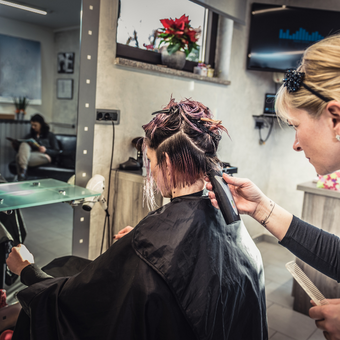 Hairdresser cuts a woman's hair