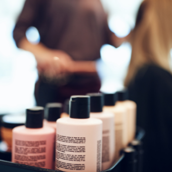 Woman receives a consultation and hair product sits on a shelf