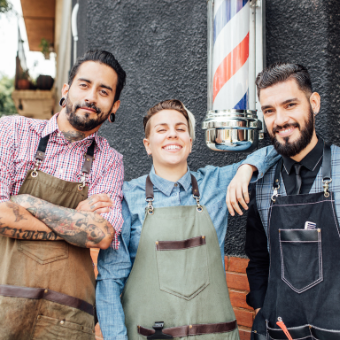 three barbers standing outside their shop