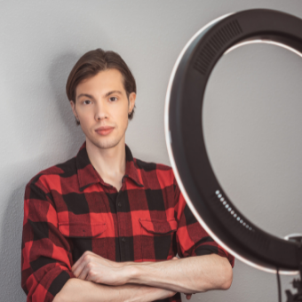 Young man hairstylist standing in front of a ring light