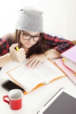 girl in beanie writing in a notebook