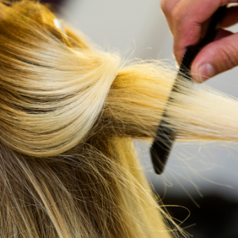 Hair stylist combs client's hair